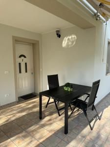 a dining room with a black table and two chairs at Appartament Tea in Šorići