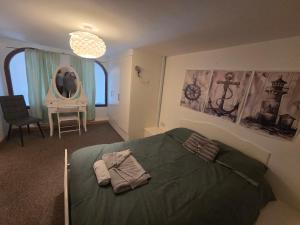 a bedroom with a green bed and a chair at Ramsgate Sea-side Stay! in Ramsgate