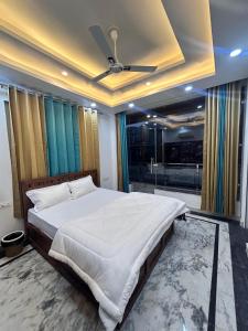 a bedroom with a large bed with a ceiling fan at The great Garuda hotel in Rishīkesh
