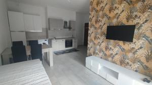 a living room with a kitchen with a tv on the wall at Leo's Villa in Milano Marittima