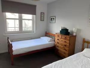 a bedroom with two beds and a dresser and a window at Irvine Harbor Apartments in Irvine