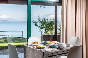 a table with food on it with a view of the ocean at Club del Sole Desenzano Boutique Resort in Desenzano del Garda