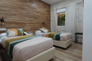 two beds in a room with wooden walls at El Hortal i lloo in El Cuervo
