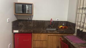 a small kitchen with a sink and a microwave at Pousada e Hotel Mirasol in Mato Verde