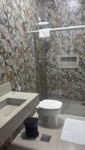 a bathroom with a toilet and a sink and a shower at Pousada e Hotel Mirasol in Mato Verde