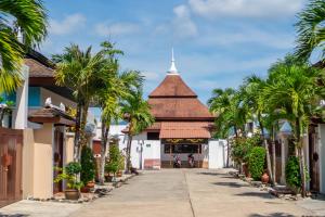 a street in a resort with palm trees at Prima Villas Chalong Phuket in Chalong