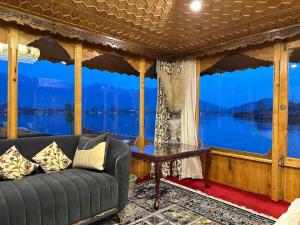 a living room with a couch and a large window at Imperial Group of Houseboats in Srinagar