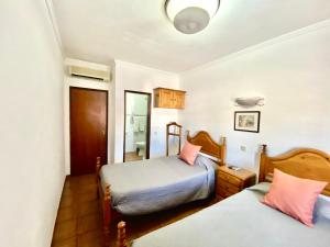 a bedroom with two beds and a mirror at Quartos de Vidigueira in Vidigueira