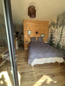a bedroom with a bed with a wooden wall at Maison Vaniméou in Pouzauges