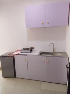 a kitchen with white cabinets and a sink at Vintage classic suits in Lagos