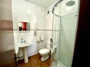 a bathroom with a toilet and a sink and a shower at Quartos de Vidigueira in Vidigueira +20 photos