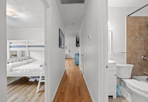 a white room with a bed and a bathroom at Central OBX Getaway with Pool and Sound Access in Nags Head +32 photos