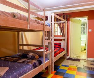 a room with three bunk beds and a doorway at Inuka Guest house in Nairobi