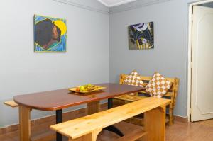 a dining room with a wooden table and a bench at Inuka Guest house in Nairobi