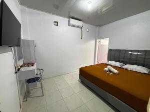 a bedroom with a bed with a teddy bear on it at Sima El Barkah in Padang