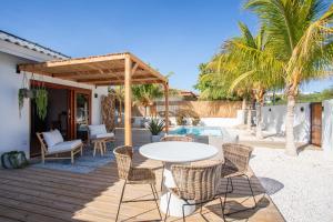 a patio with a table and chairs on a deck at Villa CuraNova in Jan Thiel