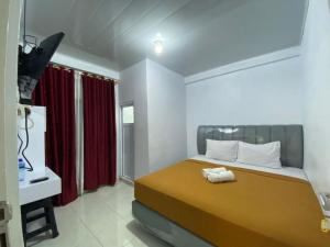 a bedroom with a bed with a red curtain at Sima El Barkah in Padang