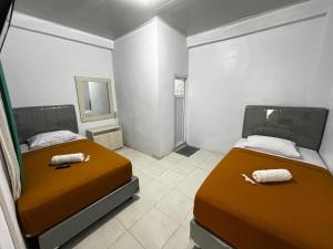 two beds in a small room with two beds sidx sidx sidx at Sima El Barkah in Padang