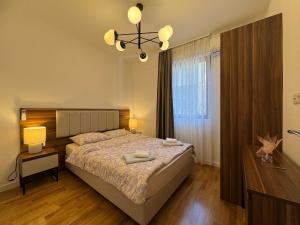 a bedroom with a bed and a chandelier at Beachfront Rafailovici - Budva in Rafailovici