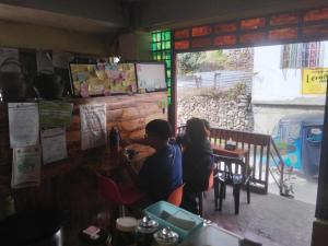 two people sitting at a table in a restaurant at grandmas homestay in Sagada