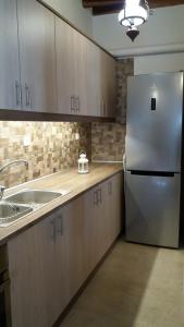 a kitchen with wooden cabinets and a stainless steel refrigerator at Studio Katerina in Kimolos