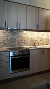 a kitchen with a sink and a stove and cabinets at Studio Katerina in Kimolos +2 photos