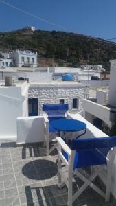 a patio with blue tables and chairs on a roof at Studio Katerina in Kimolos