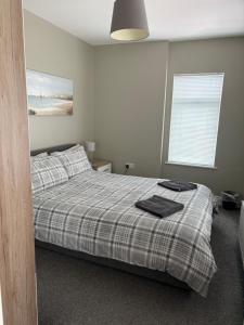 a bedroom with a bed with a plaid blanket at Binghambelle in Bangor