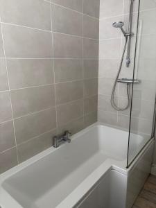 a bathroom with a bath tub with a shower at Binghambelle in Bangor