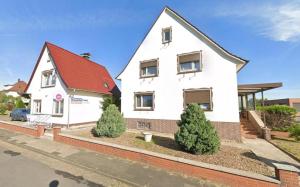 a white house with a red roof at Pension Highway - Löhne Löhner Straße 111 in Löhne