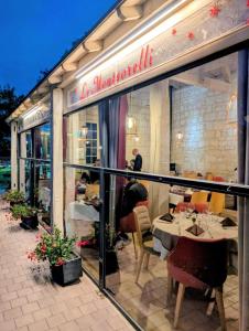 a restaurant with tables and chairs outside of a window at Logis Hôtel Le Bussy in Montsoreau