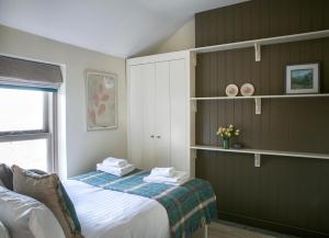 a bedroom with a bed and shelves and a window at The Green House deluxe 2 bedroom upper floor apartments in Harrogate