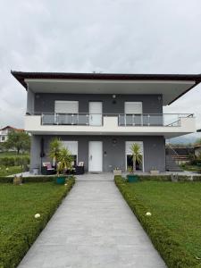 a gray house with a walkway in front of it at Dragoti in Leptokarya
