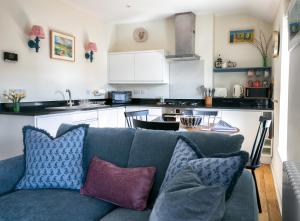 a living room with a blue couch and a kitchen at The Green House deluxe 2 bedroom upper floor apartments in Harrogate +29 photos