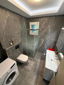 a bathroom with a toilet and a sink and a washing machine at Dragoti in Leptokarya