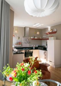 a kitchen and living room with a table with flowers at The Green House deluxe 2 bedroom upper floor apartments in Harrogate