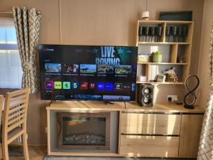 a living room with a large television on a entertainment center at 181 northfield in Skipsea