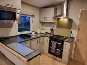 a kitchen with a stove top oven next to a sink at 181 northfield in Skipsea