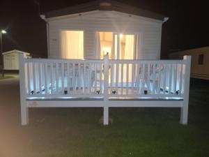 a white bench in front of a house at night at 181 northfield in Skipsea