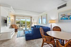 a living room with a blue couch and a table at DL104 - Dune's Watch in Nags Head