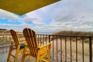 two chairs sitting on a balcony overlooking the beach at DL104 - Dune's Watch in Nags Head +32 photos