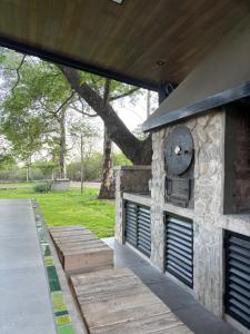 a patio with a stone fireplace with a clock on it at Loto San Lorenzo Studio I balcón, vista cerros y piscina in San Lorenzo