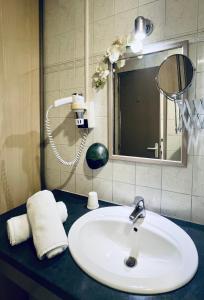 a bathroom counter with a sink and a mirror at Hôtel Ylang-Ylang in Saint-Gilles-les-Bains +33 photos