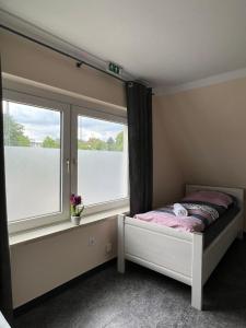 a bedroom with two windows and a bed in it at Pension Highway - Löhne Löhner Straße 111 in Löhne