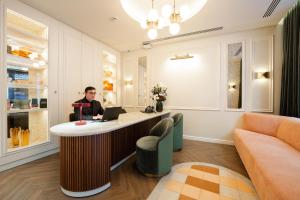 a man sitting at a bar in a room with a laptop at Hotel Condal in Barcelona