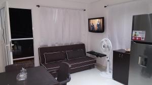 - un salon avec un canapé et une télévision dans l'établissement Apartamentos Turisticos Buena Vista, à San Andrés
