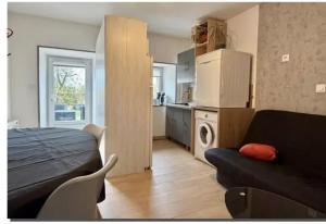 a living room with a couch and a kitchen at Le repos beaurepairien in Beaurepaire