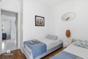 a white room with two beds and a mirror at BC Beach House - Santa Cruz in Santa Cruz