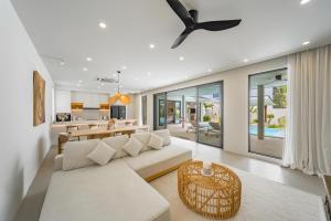 a living room with a white couch and a ceiling fan at Valentine Village in Choeng Mon Beach