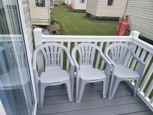 a pair of white chairs sitting on a balcony at 181 northfield in Skipsea